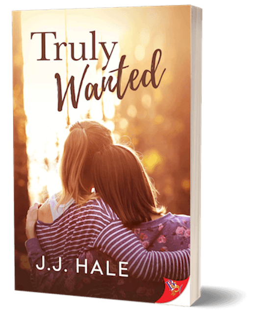 Book cover for Truly Wanted, two women leaning on eachother with backs facing the cover front. Title Truly Wanted is printed on the top of the cover and author J.J. Hale is printed on the bottom of the cover. The cover colors are orange and yellow tones.