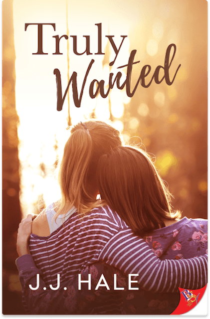 Book cover for Truly Wanted, two women leaning on eachother with backs facing the cover front. Title Truly Wanted is printed on the top of the cover and author J.J. Hale is printed on the bottom of the cover. The cover colors are orange and yellow tones.